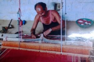 Photo of a man weaving on a loom