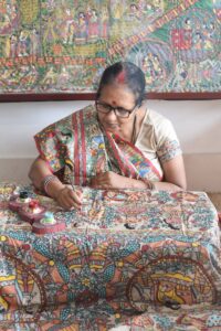 Asha Jha, Madhubani artist, working on her art on fabric.